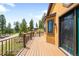 Long deck with mountain views, exterior lamp, and a black metal fence surrounding it at 10090 Blue Sky Trl, Conifer, CO 80433