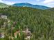 Beautiful mountain home nestled among the trees with a view of the mountains in the background at 10090 Blue Sky Trl, Conifer, CO 80433