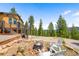 Outdoor fire pit area with seating and landscaped surroundings, perfect for evening gatherings at 10090 Blue Sky Trl, Conifer, CO 80433