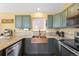 Bright kitchen with custom copper sink, granite countertops, green cabinetry and stainless steel appliances at 10090 Blue Sky Trl, Conifer, CO 80433