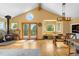 Open living room with hardwood floors, a cozy stove, and mountain views at 10090 Blue Sky Trl, Conifer, CO 80433