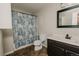Bathroom with dark vanity, toilet, bathtub and shower with blue floral shower curtain and tile floors at 431 Wright St # 203, Lakewood, CO 80228