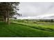 Large grassy field with trees, walking path, and buildings in the distance on a cloudy day at 431 Wright St # 203, Lakewood, CO 80228