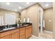 Bright bathroom features double sinks, wood cabinets, and large mirror with decorative fixtures at 12674 E Bates Cir, Aurora, CO 80014