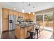 Bright kitchen boasts an island with bar seating, granite counters, wood cabinets, and stainless steel appliances at 12674 E Bates Cir, Aurora, CO 80014