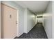 Long hallway with patterned carpet and leading to a door at 675 S Alton Way # 7A, Denver, CO 80247