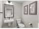 Stylish half-bathroom featuring a modern sink, toilet, mirror and attractive wall decor at 9487 W 58Th Ln # C, Arvada, CO 80002