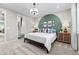 Bedroom featuring an accent wall, adjacent bathroom and modern lighting fixture at 9487 W 58Th Ln # C, Arvada, CO 80002