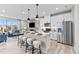 Open concept kitchen with stainless steel appliances, white cabinets, island seating, and a view into the living area at 9487 W 58Th Ln # C, Arvada, CO 80002