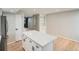 Kitchen island with quartz countertop, stainless steel appliances, hardwood floors, and modern fixtures at 1070 Race St # H, Denver, CO 80206