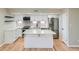 Bright, modern kitchen features white cabinets, stainless steel appliances, and a center island with quartz countertop at 1070 Race St # H, Denver, CO 80206