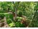Landscaped backyard featuring lush greenery, trees, and a stone pathway to create a serene outdoor space at 4532 Christensen Cir, Littleton, CO 80123