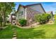 Landscaped backyard featuring a well-manicured lawn, stone walkway, and deck at 4532 Christensen Cir, Littleton, CO 80123