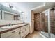 Contemporary bathroom with a double sink vanity, granite countertop, and tiled shower at 4532 Christensen Cir, Littleton, CO 80123