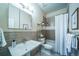 Well-lit bathroom featuring a shower-tub, vanity, framed art, and attractive neutral tiling at 4532 Christensen Cir, Littleton, CO 80123