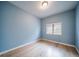 Bright bedroom with light blue walls, hardwood floors, and a window with blinds at 4532 Christensen Cir, Littleton, CO 80123