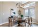 Elegant dining area featuring a modern chandelier, seating for six, and a decorative art piece at 4532 Christensen Cir, Littleton, CO 80123