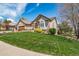 Well-maintained lawn and landscaping surround this brick home featuring a three-car garage at 4532 Christensen Cir, Littleton, CO 80123