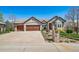 Beautiful brick home featuring a three-car garage and well-maintained landscaping, including house number at 4532 Christensen Cir, Littleton, CO 80123
