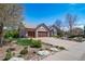 Charming brick home boasts a three-car garage and beautifully landscaped front yard on a sunny day at 4532 Christensen Cir, Littleton, CO 80123