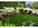 Landscaped front yard with lush lawn, mature trees, and beautiful shrubbery, providing great curb appeal at 4532 Christensen Cir, Littleton, CO 80123