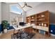 Sun-filled home office features custom shelving, an oversized window, and a modern ceiling fan at 4532 Christensen Cir, Littleton, CO 80123