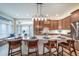 Beautiful kitchen island with seating, stainless steel appliances, modern pendant lights, and hardwood flooring at 4532 Christensen Cir, Littleton, CO 80123