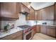 A modern kitchen with stainless appliances, granite countertops, and wood cabinets is perfect for cooking at 4532 Christensen Cir, Littleton, CO 80123