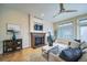 Cozy living room with a fireplace, hardwood floors, and a stylish ceiling fan at 4532 Christensen Cir, Littleton, CO 80123