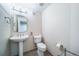 Well-lit powder room with pedestal sink, mirror, and toilet at 4532 Christensen Cir, Littleton, CO 80123