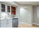 Modern wet bar featuring granite countertops, white cabinets, and stainless steel refrigerator at 4532 Christensen Cir, Littleton, CO 80123