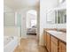 Well-lit bathroom showcasing tile floors, a bathtub and access to main bedroom at 9763 E Carolina Pl, Aurora, CO 80247