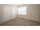 Well-lit bedroom featuring a window, plush carpet, and a sliding closet door at 9763 E Carolina Pl, Aurora, CO 80247