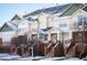 Charming townhome exterior with brick accents, inviting entryway, and snowy landscape, offering curb appeal and a welcoming atmosphere at 9763 E Carolina Pl, Aurora, CO 80247