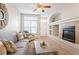 Bright living room featuring a fireplace, a large window, and modern furnishings at 9763 E Carolina Pl, Aurora, CO 80247