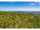 Scenic aerial view showcasing the wooded home site with mountain views and lush trees at 8838 Hillview Rd, Morrison, CO 80465