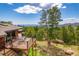 Inviting back deck with table and chairs offers scenic views of lush trees and beautiful natural surroundings at 8838 Hillview Rd, Morrison, CO 80465