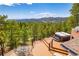 Back deck featuring a hot tub, wrought iron table set, and mountain views at 8838 Hillview Rd, Morrison, CO 80465