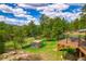Serene backyard featuring a cozy chicken coop and a spacious deck with scenic views of the lush landscape at 8838 Hillview Rd, Morrison, CO 80465