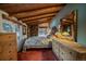 Cozy bedroom with a stone wall, wood ceiling, and ample natural light at 8838 Hillview Rd, Morrison, CO 80465