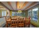 Charming dining room features a wooden table, exposed beams, and a delightful view at 8838 Hillview Rd, Morrison, CO 80465