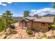 Charming exterior elevation of a home featuring natural rock details and a spacious deck at 8838 Hillview Rd, Morrison, CO 80465