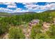 A charming home surrounded by tall trees and rocky terrain, complete with an inviting deck and outdoor seating at 8838 Hillview Rd, Morrison, CO 80465