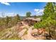 Beautiful exterior featuring mature trees, a stone pathway, and a serene patio area with comfortable seating at 8838 Hillview Rd, Morrison, CO 80465