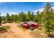 Aerial view of a red home with lush trees, circular driveway and ample parking at 8838 Hillview Rd, Morrison, CO 80465