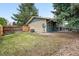 Spacious backyard with well-maintained lawn, rock features, patio, and partial privacy fence at 2495 S Lansing Way, Aurora, CO 80014