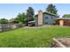 Spacious backyard with lush lawn, privacy fence, patio area, and mature trees at 2495 S Lansing Way, Aurora, CO 80014