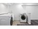 Modern laundry room featuring updated appliances and tiled flooring at 2495 S Lansing Way, Aurora, CO 80014
