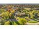 Expansive aerial shot of the property showcasing its beautifully landscaped grounds surrounded by colorful autumn trees at 9 Sedgwick Dr, Englewood, CO 80113