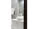 Modern bathroom showcasing marble sink, white cabinetry, chrome hardware, and decorative grey textured walls at 9 Sedgwick Dr, Englewood, CO 80113